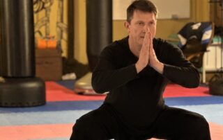 Andreas steht im Qigong-Tiefstand im Unterrichtsraum.